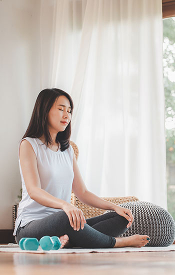 Asian woman doing yoga meditation at home
